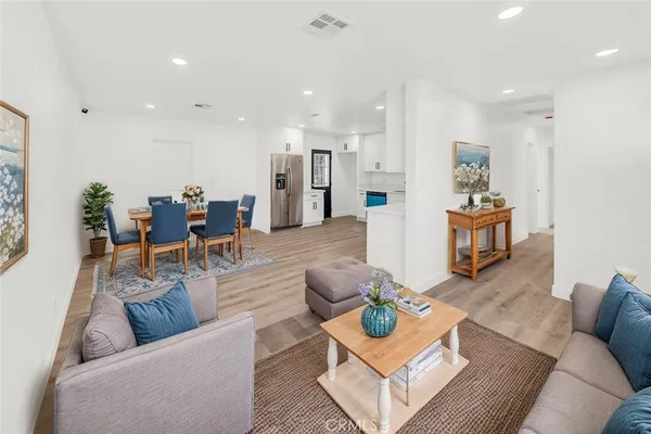 a living room with furniture kitchen view and a table