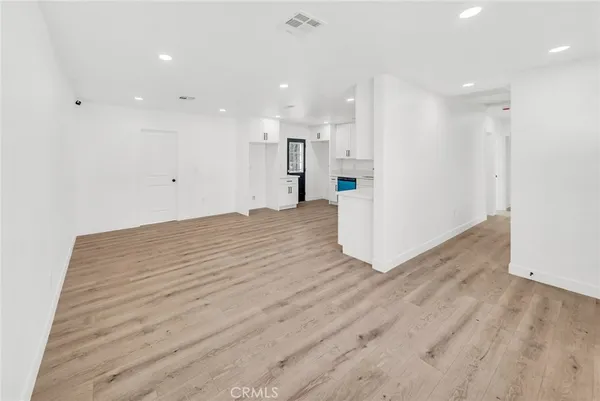a view of a big room with wooden floor and a window