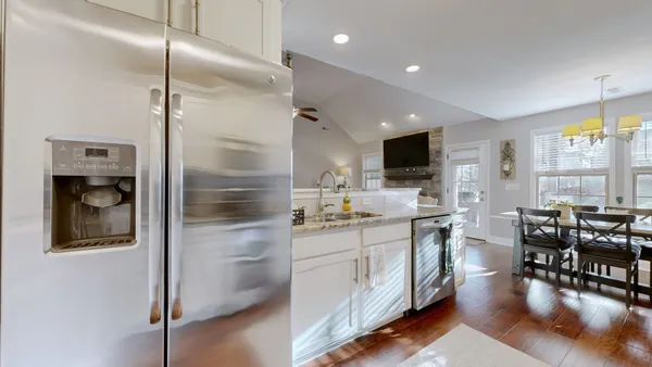 a kitchen with kitchen island a counter top space a sink stainless steel appliances and cabinets