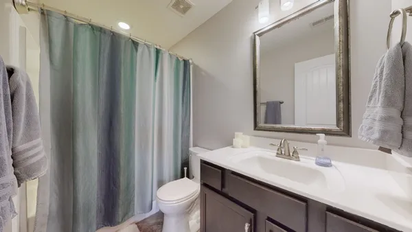 a bathroom with a double vanity sink toilet and a mirror