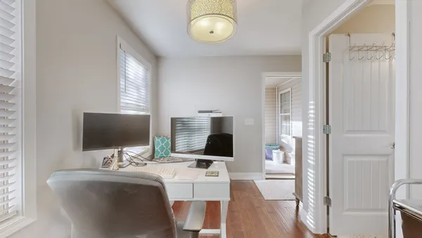 a view of a workspace with furniture and wooden floor