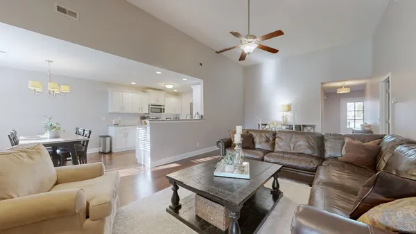 a living room with furniture kitchen view and a table