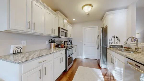 a kitchen with granite countertop a sink stainless steel appliances and cabinets
