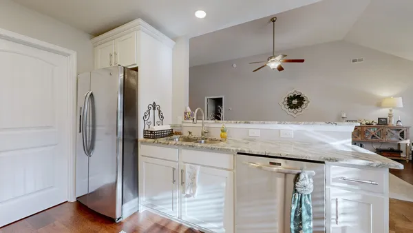 a kitchen with stainless steel appliances granite countertop a sink a refrigerator and a granite counter tops