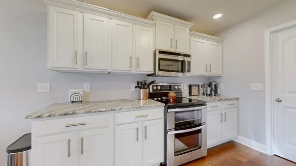 a kitchen with granite countertop white cabinets and stainless steel appliances