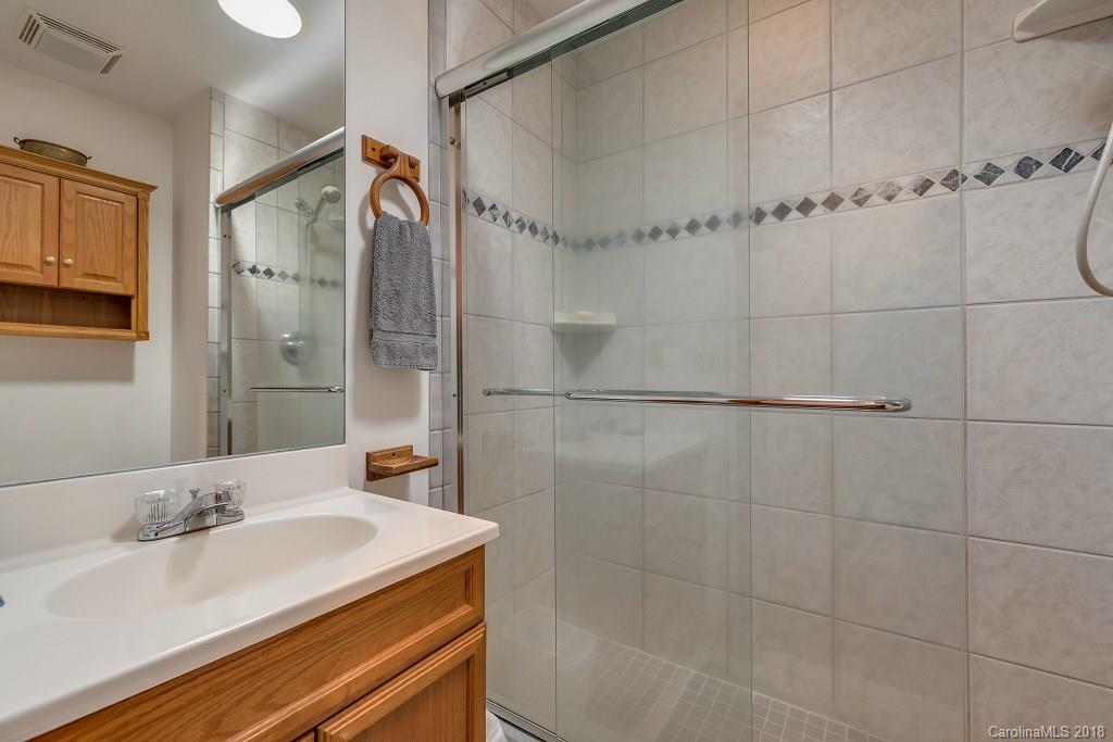2141 Coxe Road, Unit 96 Rutherfordton, NC 28139 - Photo 16 of 25 a bathroom with a granite countertop sink a shower and a mirror