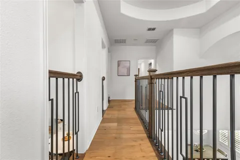 wooden floor in a room with a window and a chandelier