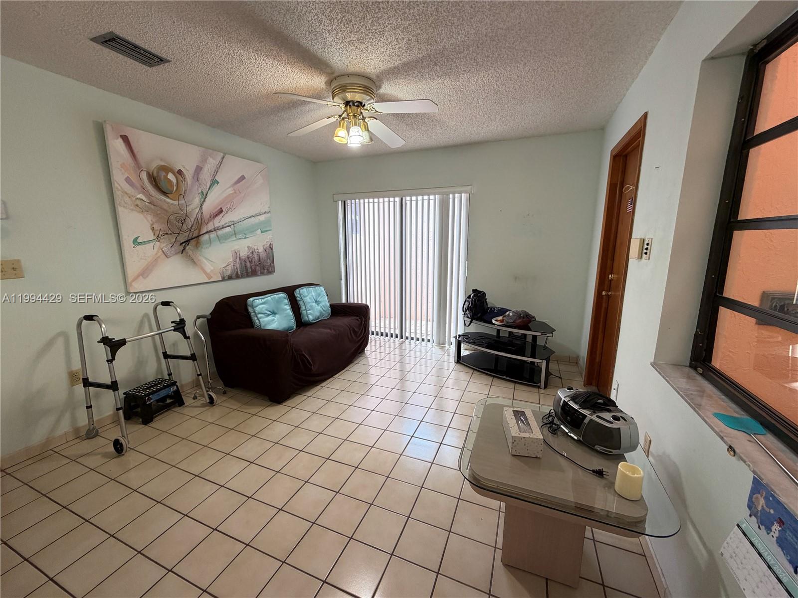 13470 Southwest 27th Street Miami, FL 33175 - Photo 6 of 11 a living room with furniture a flat screen tv and a window