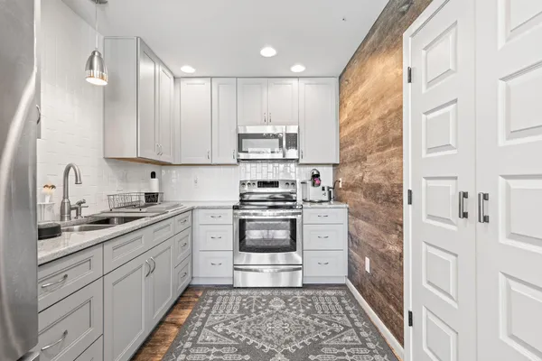 a kitchen with a white stove top oven and cabinets