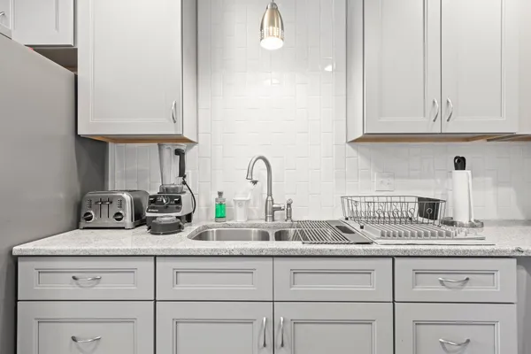 a kitchen with white cabinets and a sink