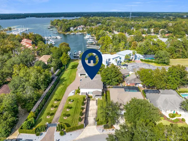 an aerial view of a house with a garden and lake view