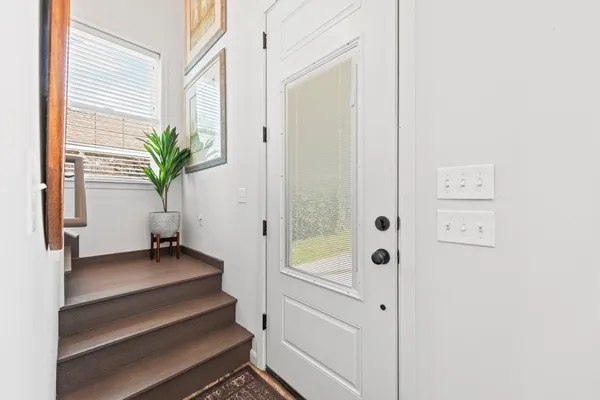 a view of a hallway with wooden floor and front door