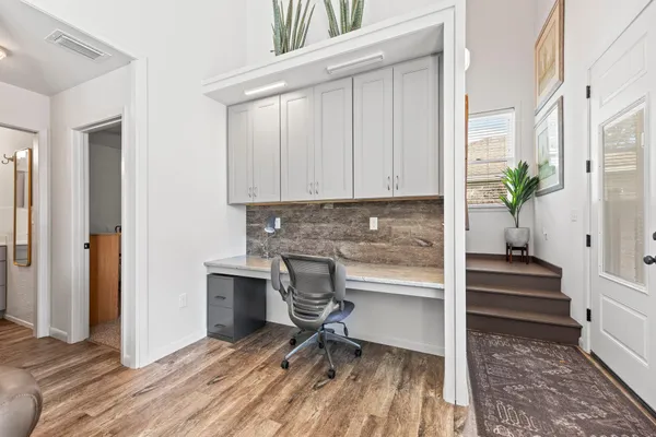 a view of a workspace with wooden floor and staircase