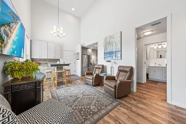 a living room with furniture a rug and kitchen view