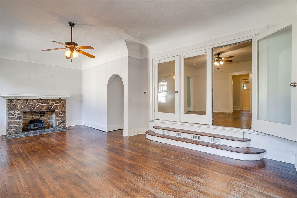 2312 Mistletoe Avenue Fort Worth, TX 76110 - Photo 14 of 40 a view of a livingroom with a fireplace and wooden floor