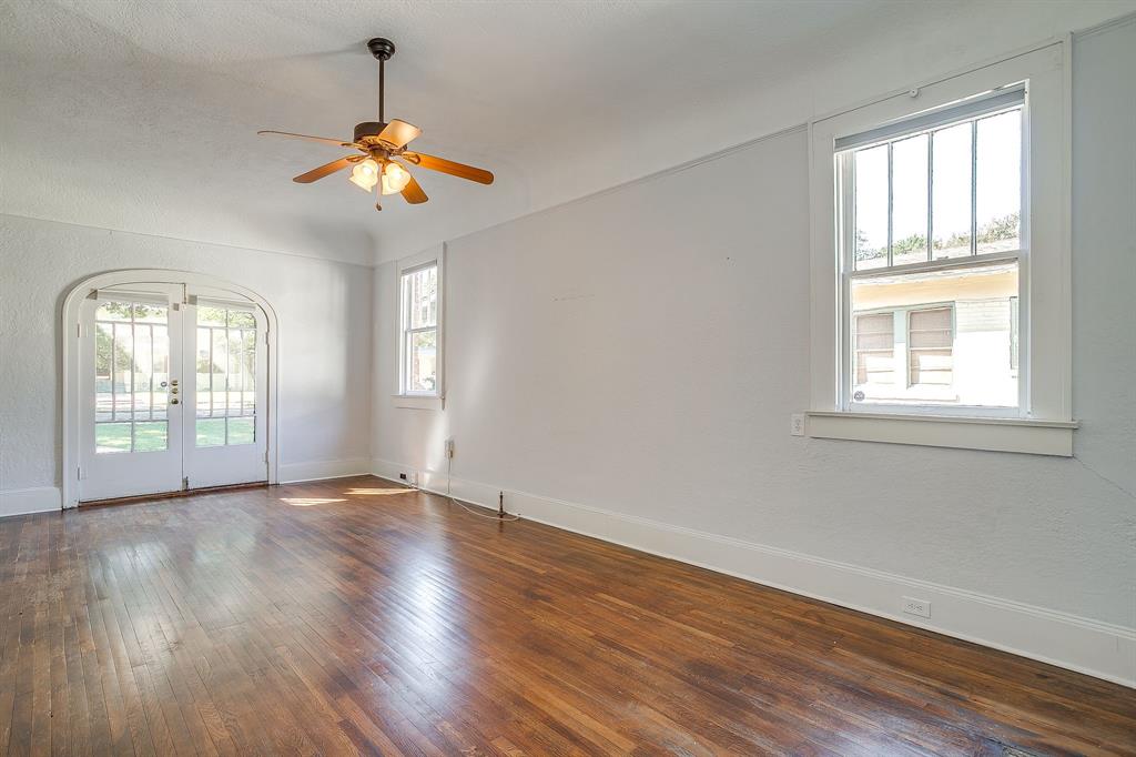 2312 Mistletoe Avenue Fort Worth, TX 76110 - Photo 17 of 40 a view of an empty room with wooden floor and a window
