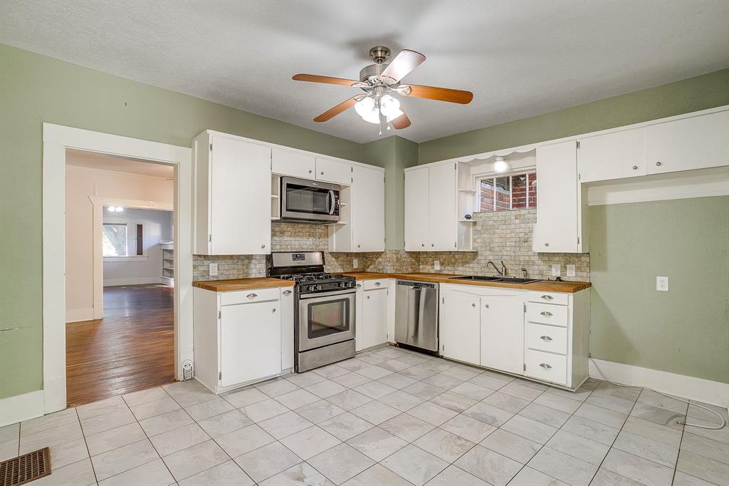 2312 Mistletoe Avenue Fort Worth, TX 76110 - Photo 34 of 40 a kitchen with a stove a sink and a refrigerator