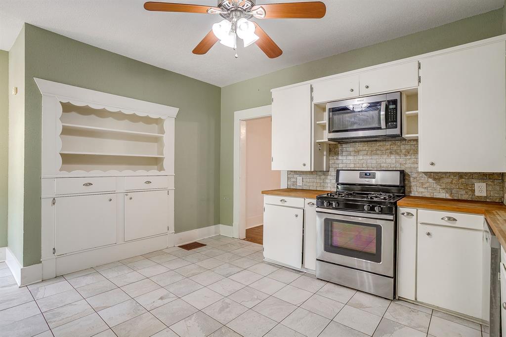 2312 Mistletoe Avenue Fort Worth, TX 76110 - Photo 35 of 40 a kitchen with stainless steel appliances granite countertop a stove and a sink