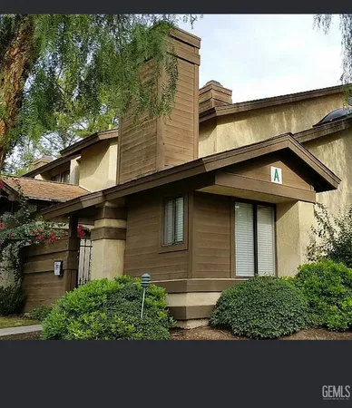 a view of a house with a large window and a yard in front of it