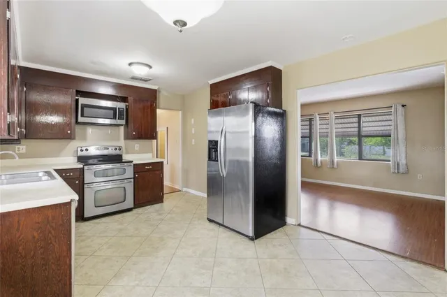 a kitchen with granite countertop a refrigerator and a stove top oven