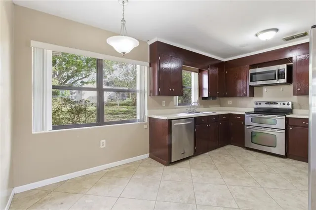 a kitchen with stainless steel appliances granite countertop a stove sink and microwave