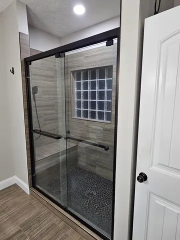 a bathroom with a glass door shower