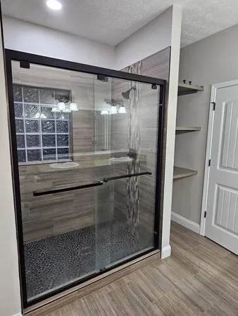 a bathroom with a glass door shower and a mirror