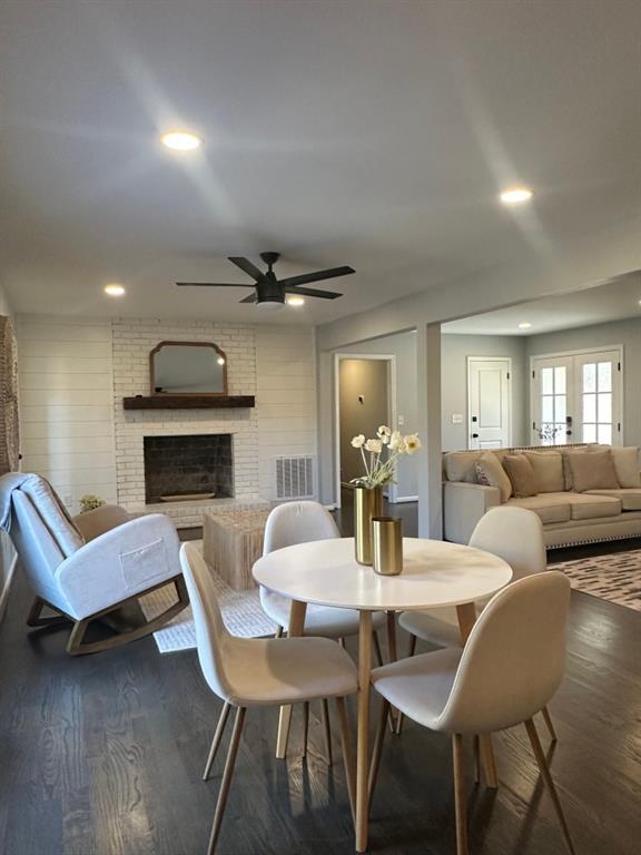 172 Thompson Place Gainesville, GA 30506 - Photo 5 of 32 a living room with furniture a fireplace and a dining table with wooden floor