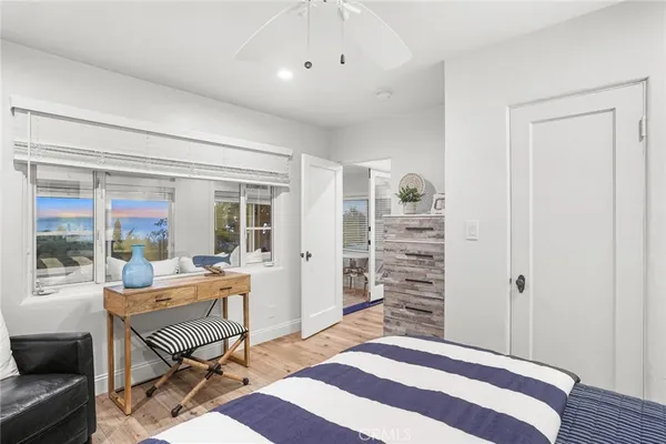 a bedroom with a bed a large window and walk in closet