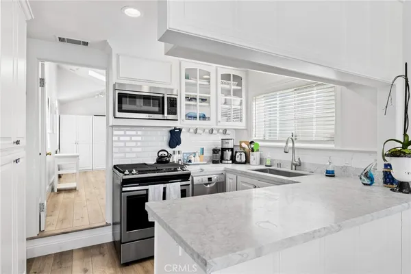 a kitchen with stainless steel appliances a stove a sink a refrigerator and cabinets