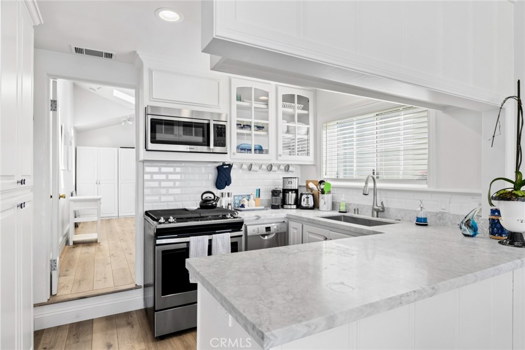2915 Rounsevel Terrace Laguna Beach, CA 92651 - Photo 9 of 32 a kitchen with stainless steel appliances a stove a sink a refrigerator and cabinets