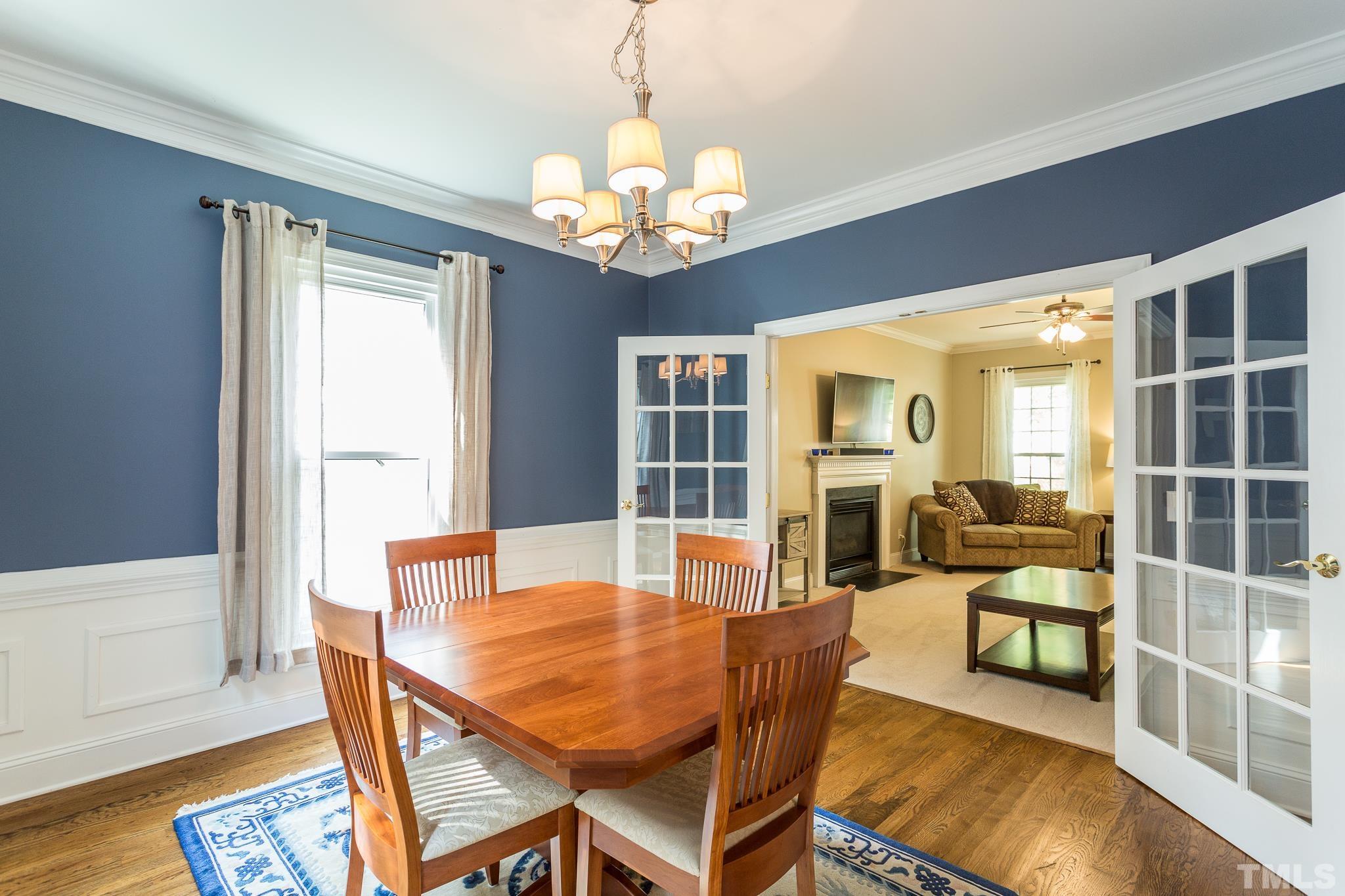 5225 Covington Bend Drive Raleigh, NC 27613 - Photo 11 of 30 a dining room with wooden floor a chandelier a wooden table and chairs