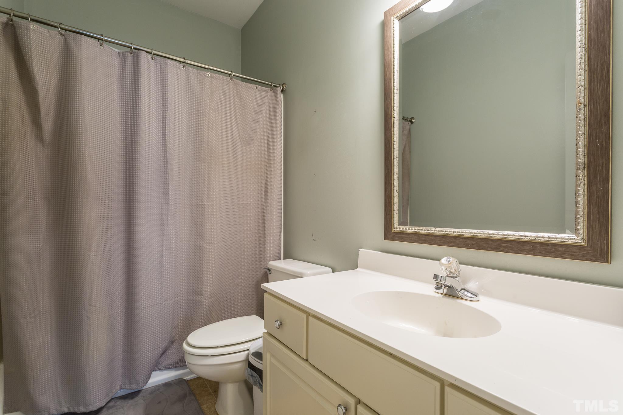 5225 Covington Bend Drive Raleigh, NC 27613 - Photo 24 of 30 a bathroom with a sink a toilet and shower curtain