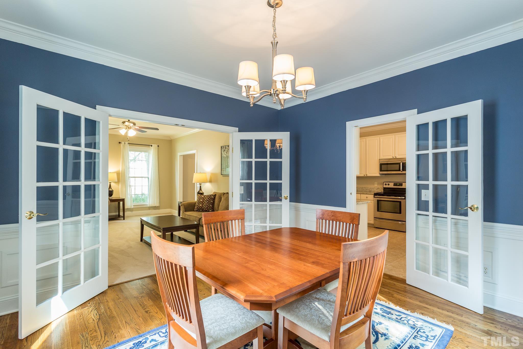 5225 Covington Bend Drive Raleigh, NC 27613 - Photo 10 of 30 a dining room with wooden floor a chandelier a glass table and chairs