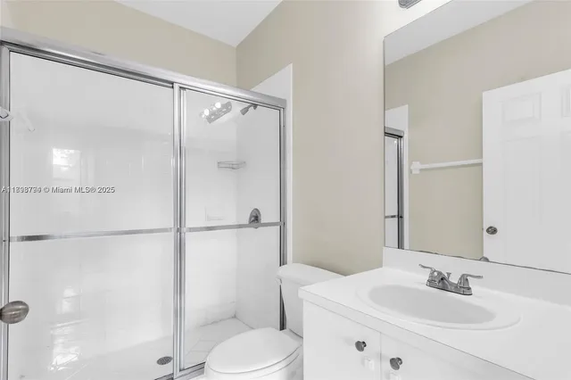 a bathroom with a sink mirror shower and toilet