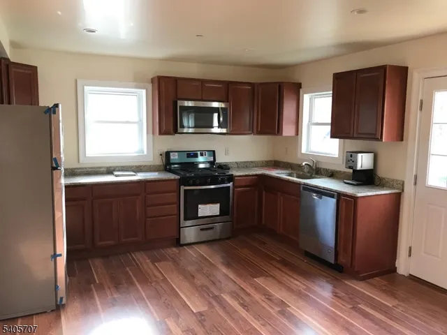 a kitchen with stainless steel appliances granite countertop a stove a sink dishwasher and a refrigerator