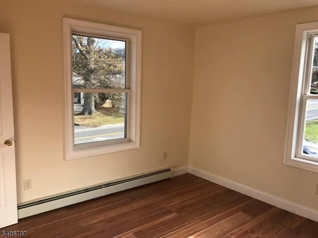 an empty room with wooden floor and a window