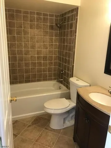 a bathroom with a granite countertop toilet a sink and bathtub