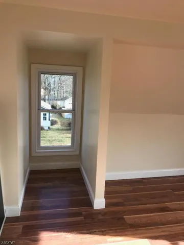 a view of a small space with wooden floor and a window