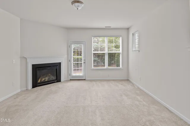 an empty room with a fireplace and window