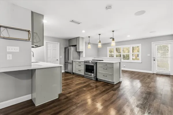 a large kitchen with stainless steel appliances a stove and a refrigerator