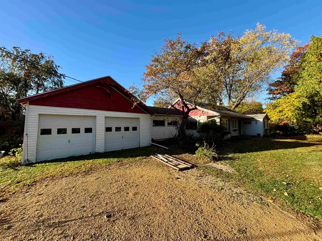 a front view of house with yard and trees in the background