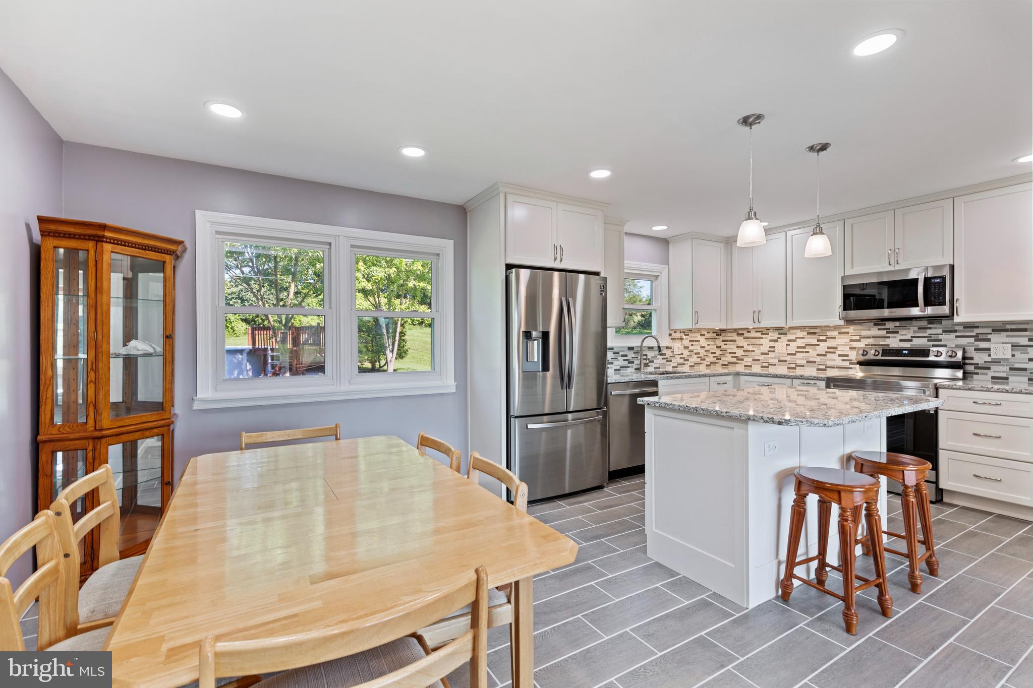 4067 East Texas Road Allentown, PA 18103 - Photo 12 of 37 a kitchen with a refrigerator a stove top oven a sink dishwasher and dining table with wooden floor