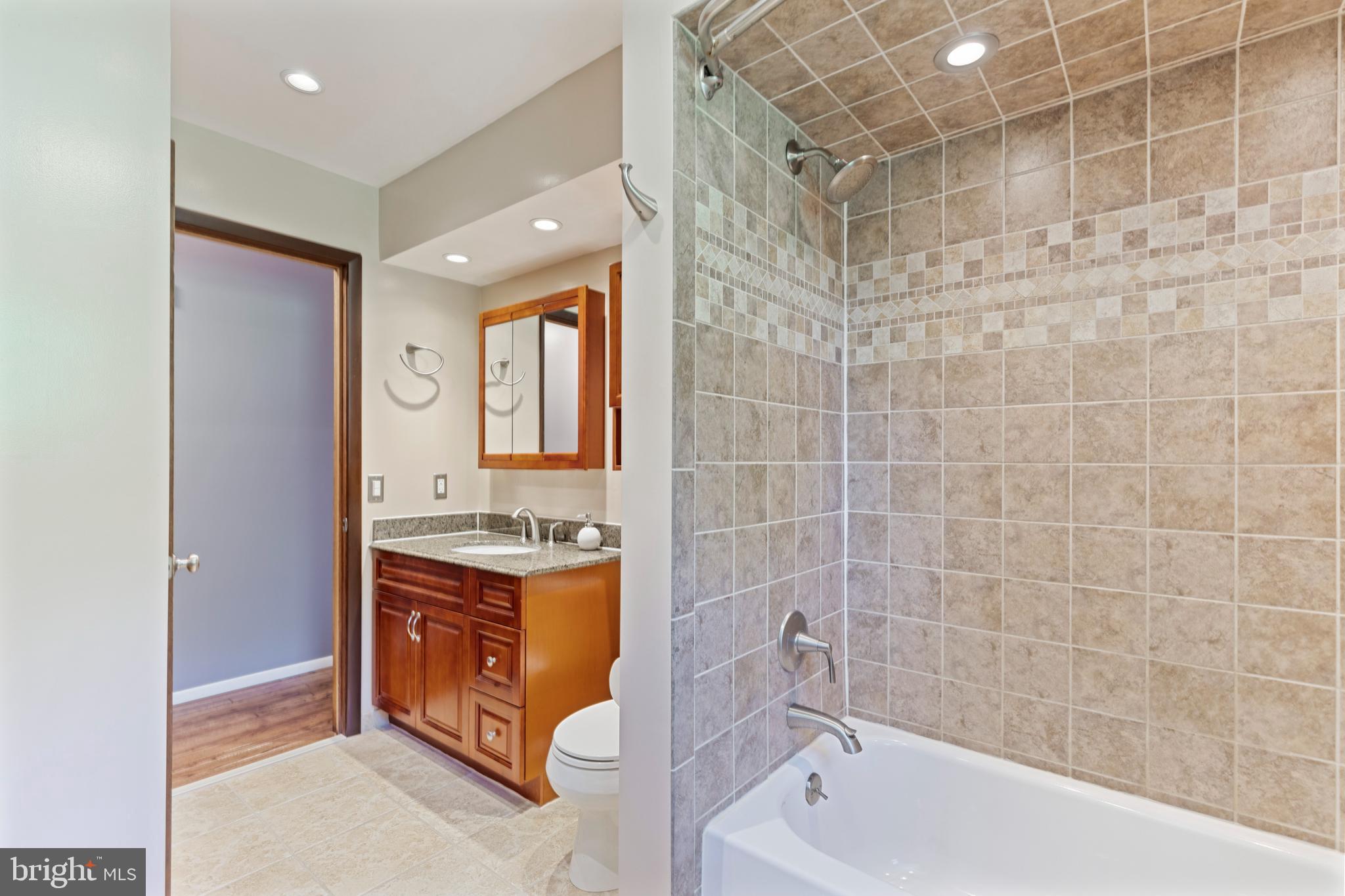 4067 East Texas Road Allentown, PA 18103 - Photo 17 of 37 a bathroom with a granite countertop sink a toilet and shower