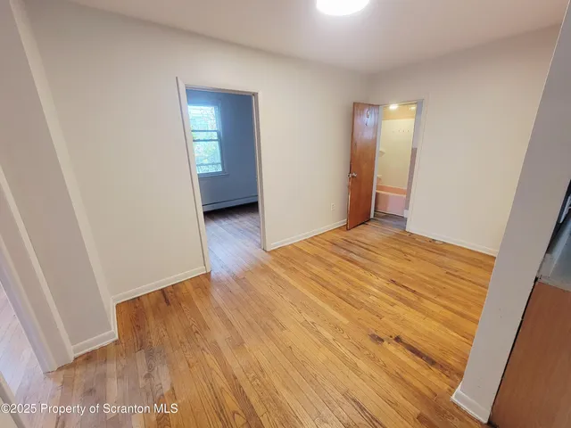 a view of a room with wooden floor and entryway