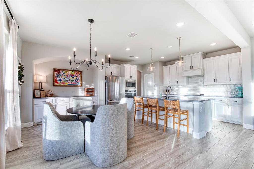 12605 Eagles Bluff Godley, TX 76044 - Photo 15 of 39 a dining room with stainless steel appliances kitchen island granite countertop a table chairs and a stove