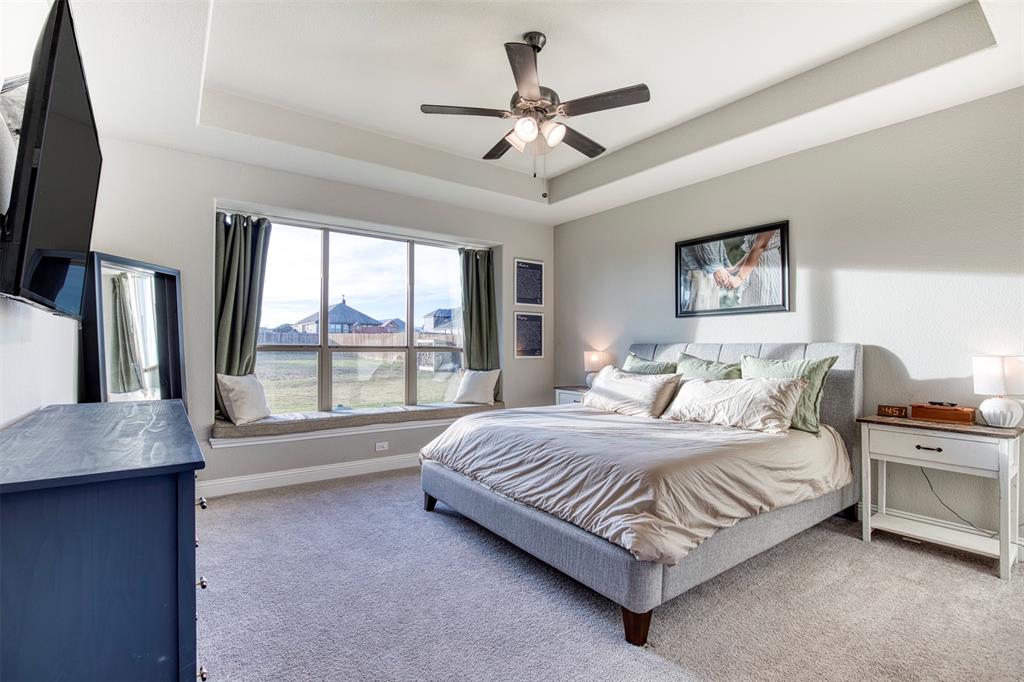 12605 Eagles Bluff Godley, TX 76044 - Photo 17 of 39 a spacious bedroom with a large bed and a chandelier