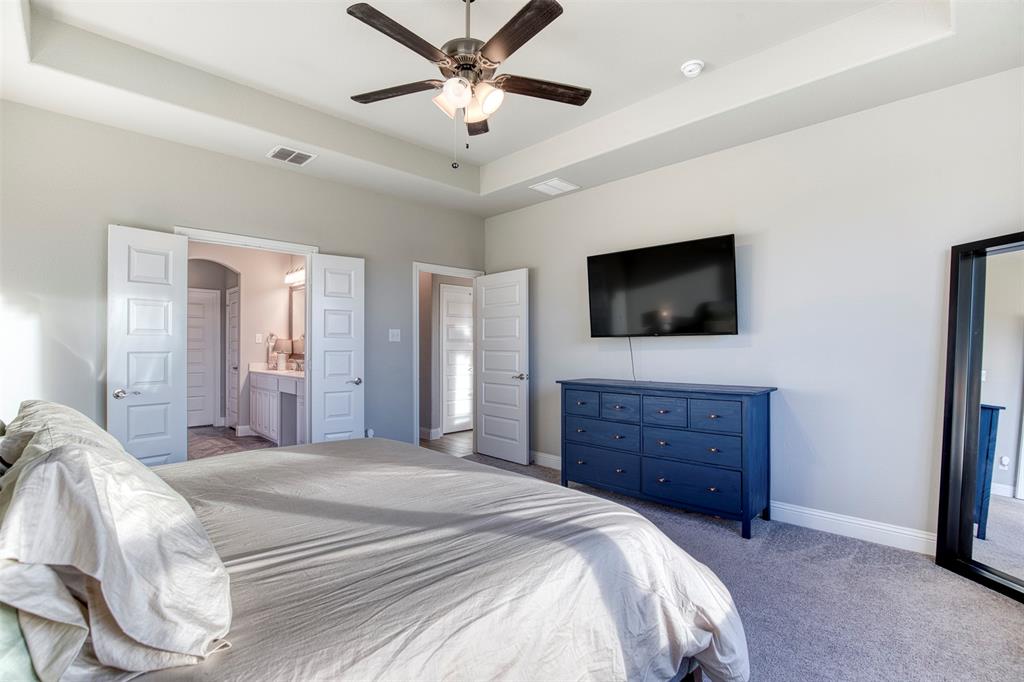 12605 Eagles Bluff Godley, TX 76044 - Photo 18 of 39 a bedroom with a bed a mirror on dresser and a flat screen tv