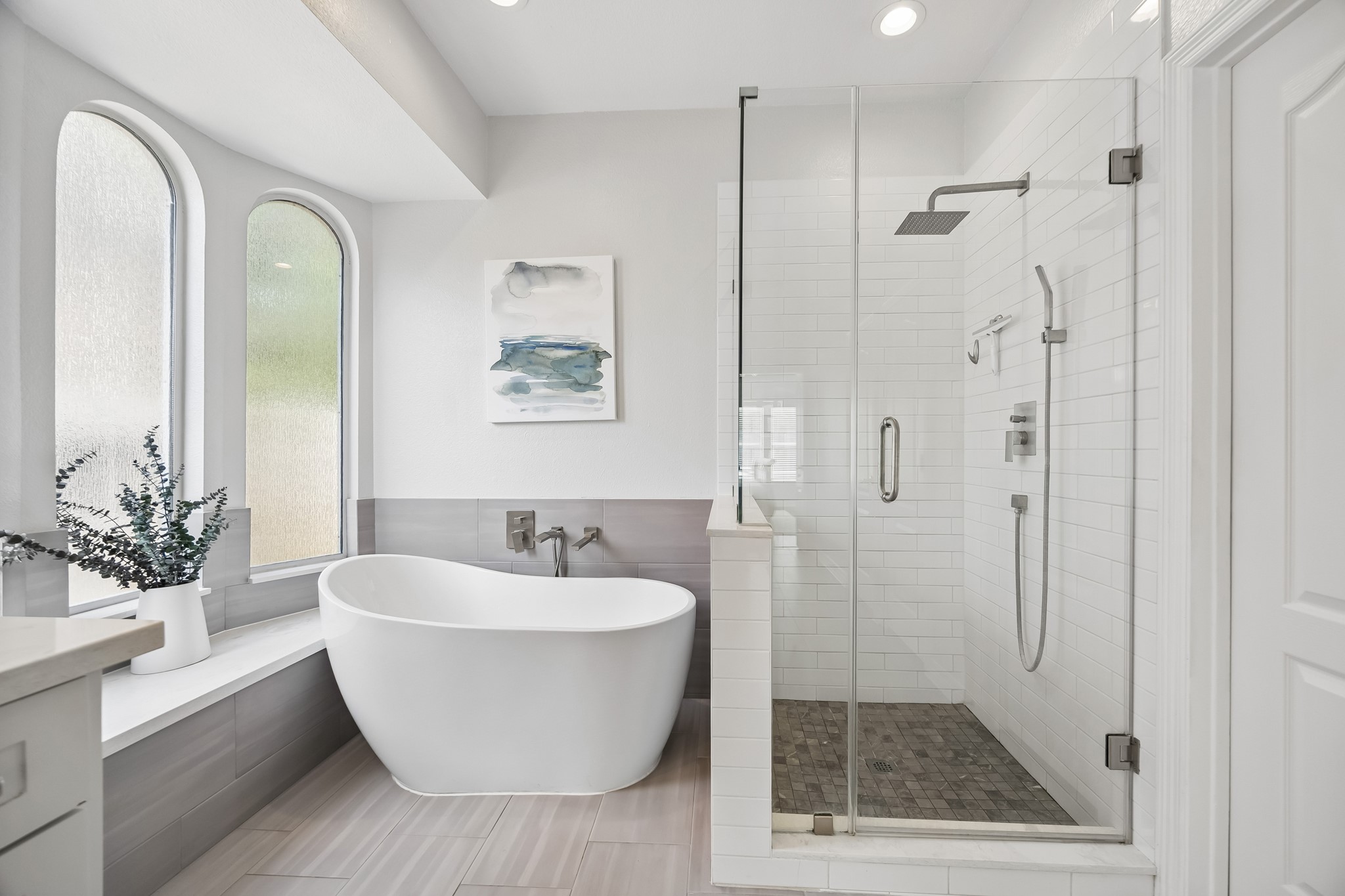 5718 Brennan Ridge Lane Katy, TX 77450 - Photo 19 of 42 DESIGNED FOR DAILY INDULGENCE: Unwind in the modern soaking tub or refresh in the oversized walk-in shower featuring polished subway tile, seamless glass, and updated fixtures.