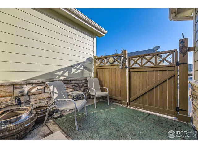 a view of a patio with table and chairs with wooden fence